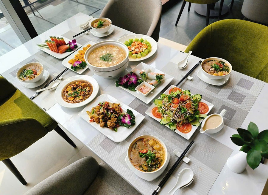 테이블 위에 샐러드, 수프, 두부 요리, 닭고기 볶음 등 여러 접시의 요리가 정갈하게 차려진 모습입니다.