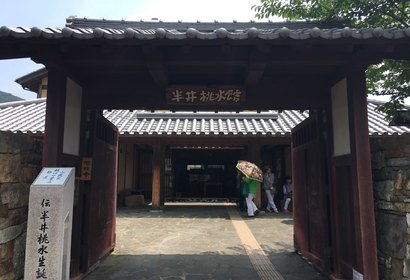기와지붕 문과 한자 현판이 걸린 일본 전통 가옥 입구와 표석