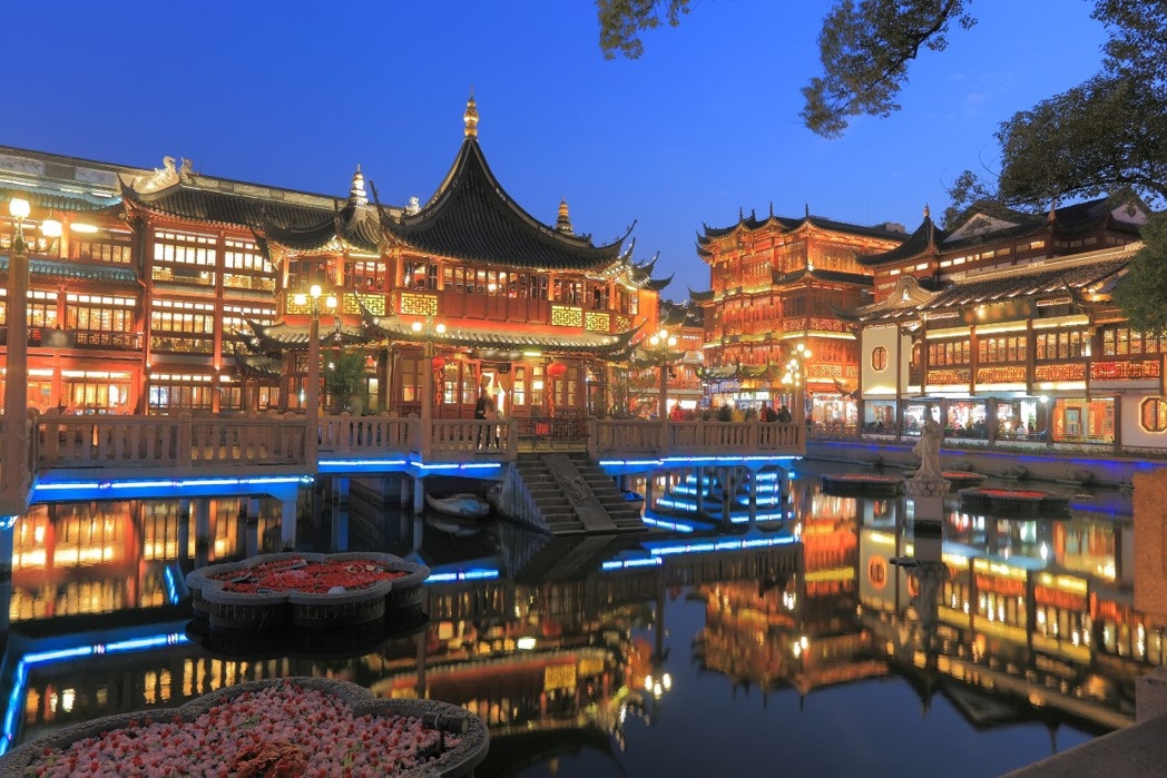 푸른 저녁 하늘 아래 고풍스러운 중국 전통 건축물과 호수, 다리에 화려한 야간 조명이 켜진 예원 주변 야경 전경입니다.