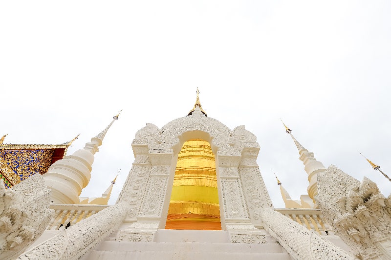하얀 아치형 건축 구조물 사이로 중앙의 거대한 황금빛 쩨디(탑)가 보입니다.